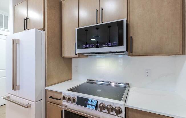 A modern kitchen with a stainless steel stove and a white refrigerator.