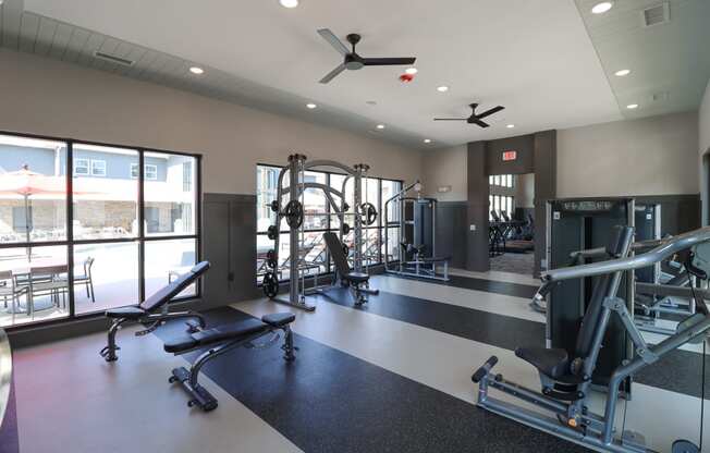 a gym with weights and other exercise equipment and windows at The Crest at Acworth, Georgia, 30102