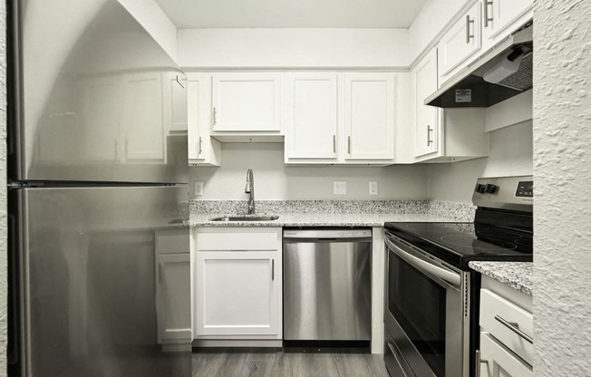 a kitchen with refrigerator and white cabinets at Southridge, Kansas City, Kansas