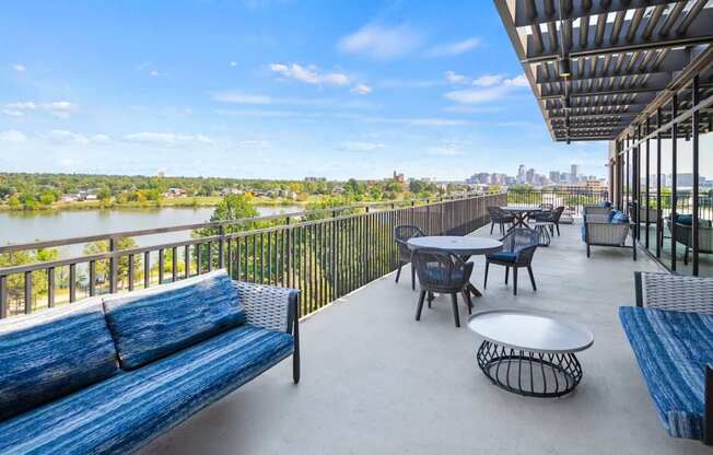 A balcony with a table and chairs overlooking a river.