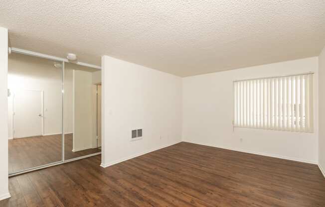 Bedroom with Hardwood Floors and Mirrored Wardrobe Closet