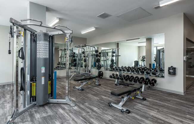 a gym with weights and cardio equipment in a building with white walls