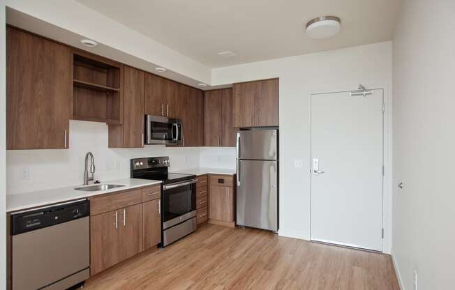 an empty kitchen with wooden cabinets and stainless steel appliances