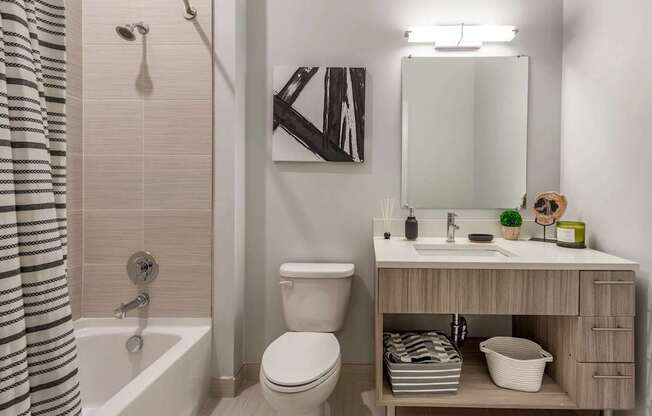 A bathroom with a toilet, sink, and a shower curtain.