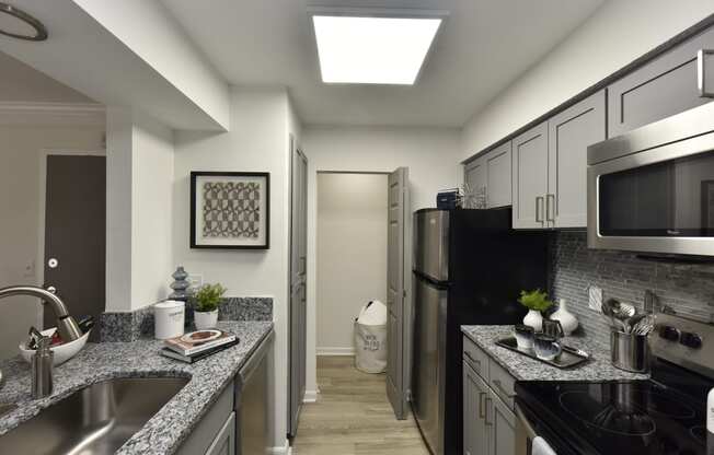 a kitchen with granite counter tops and a stainless steel refrigerator