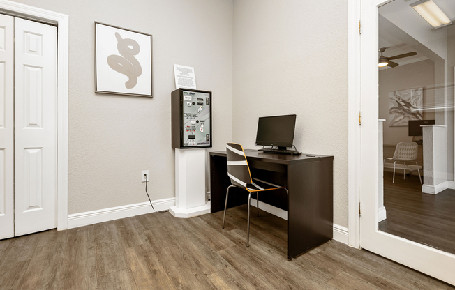 Elegant and cozy office nook with a minimalist desk, chic computer setup, and modern art, perfect for a productive work environment.