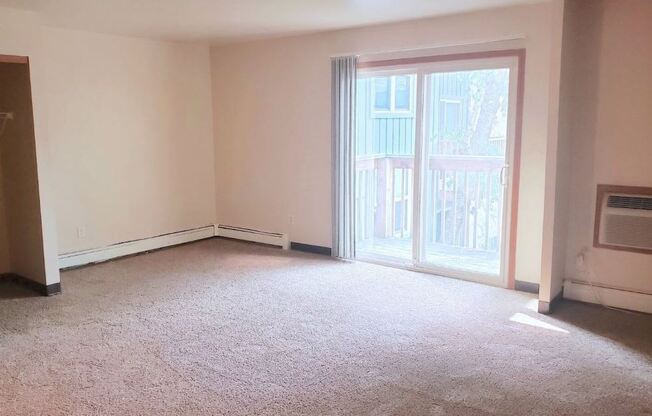 an empty room with a large window and a radiator