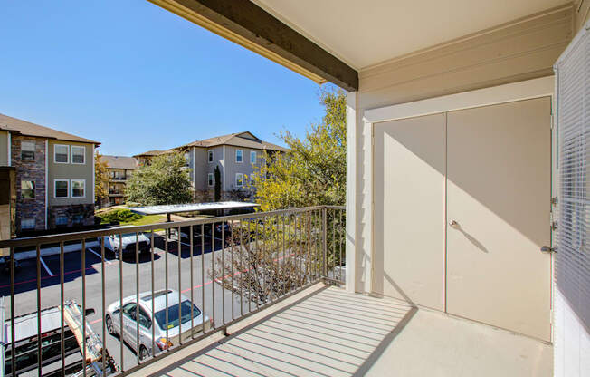 a balcony with a door and a parking lot in front of it