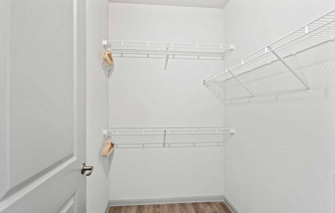 a spacious closet with white walls and a white closet door