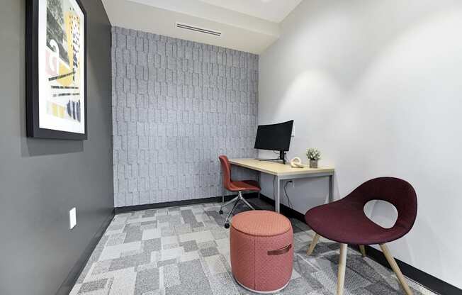 A room with a desk, chair, and a trash can.