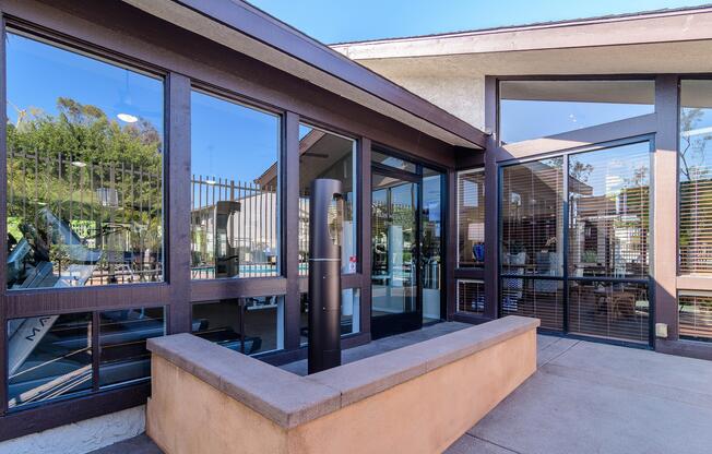 A modern building with a glass door and a brown railing.