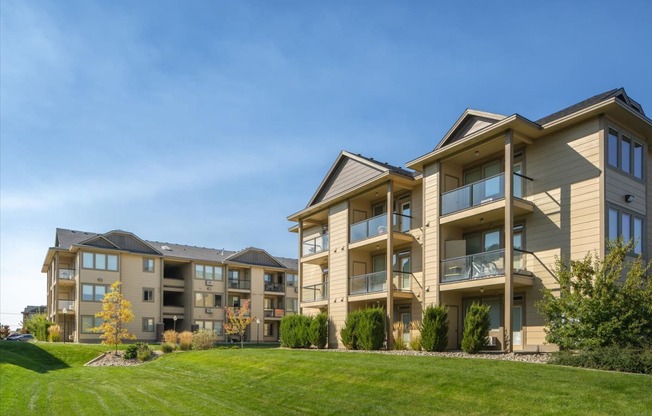 an apartment building with a green lawn in front of it