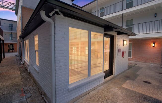 the front of a white building with glass windows