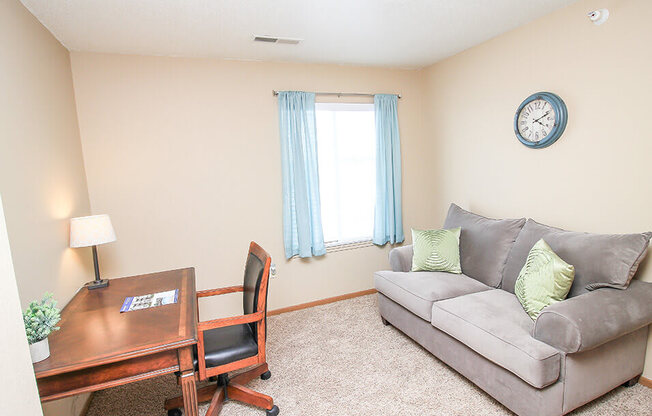 a living room with a couch and a desk
