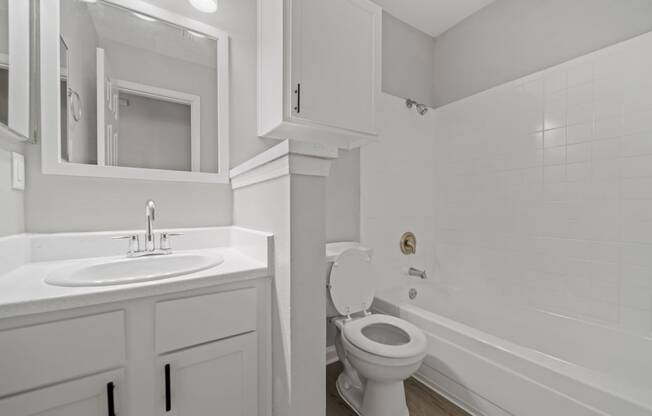 a white bathroom with a sink toilet and tub