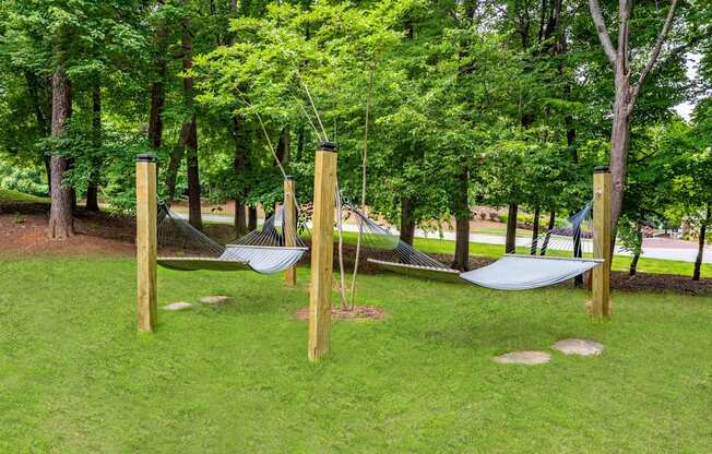 A playground with a hammock between two wooden posts.