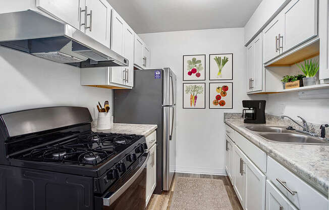 An upgraded kitchen with white cabinets and stainless steel appliances at Wingate Apartments, Michigan