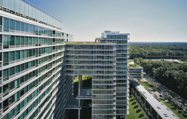 A modern glass building with a clear blue sky in the background.