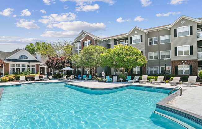 A large swimming pool in front of apartment buildings.