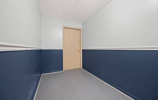 A room with a closed door and a grey floor.