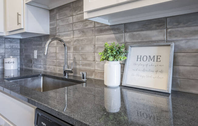 Designer Grohe-brand faucets, granite countertops and kitchen backsplash at Ascend at Woodbury MN 55129 new luxury apartments