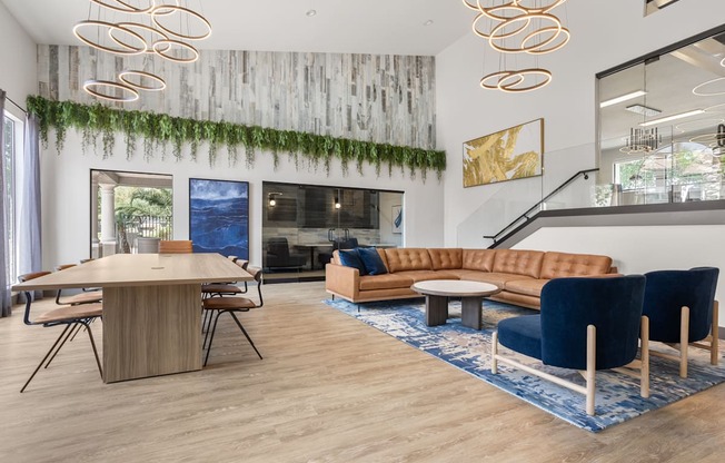 A modern living room with a wooden table and blue chairs.