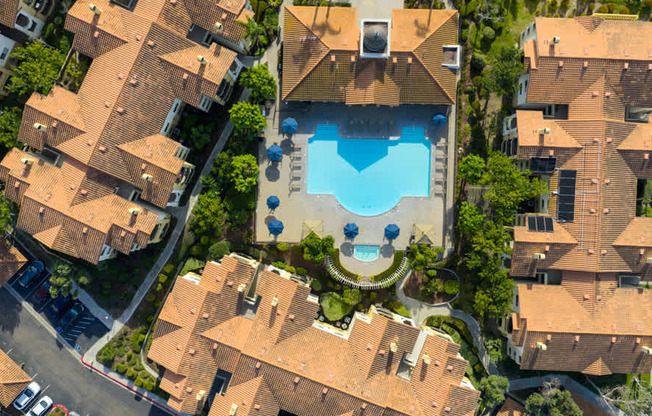 A bird's eye view of a residential area with a swimming pool.