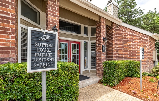 A sign in front of a building that says Sutton House Future Resident Parking.