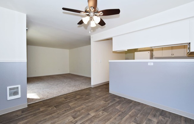 an empty living room with a ceiling fan