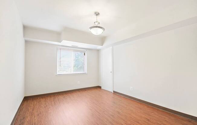 Empty room with wooden floor and white walls.