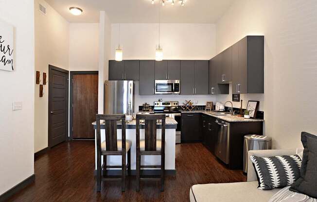 a view of a kitchen and a living room with a table and chairs