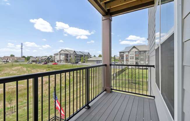 the view from the balcony of an apartment building with a flag on the balcony railing atThe Depot Raymore, MO 64083