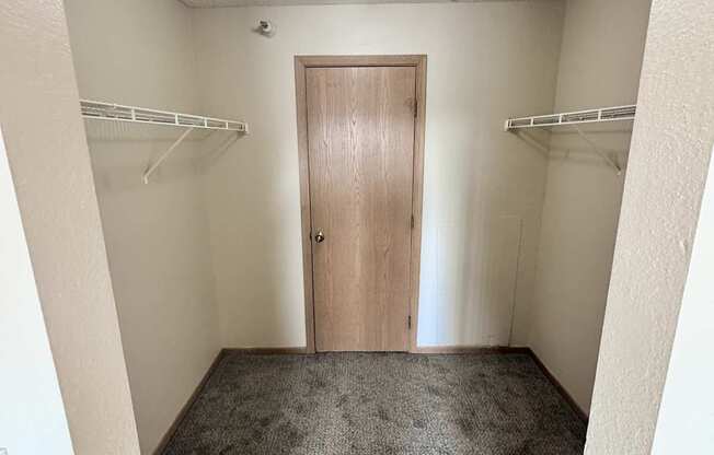 A hallway with a light on and a door at the end.
