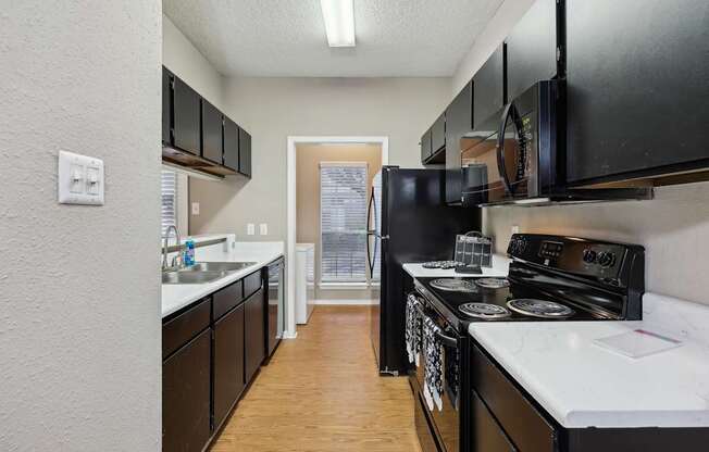 A kitchen with black cabinets and white countertops.