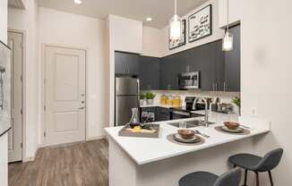 a kitchen with a large island and a stainless steel refrigerator