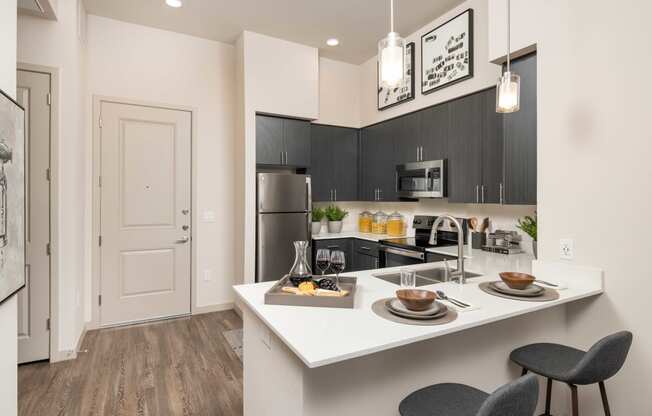 a kitchen with a large island and a stainless steel refrigerator