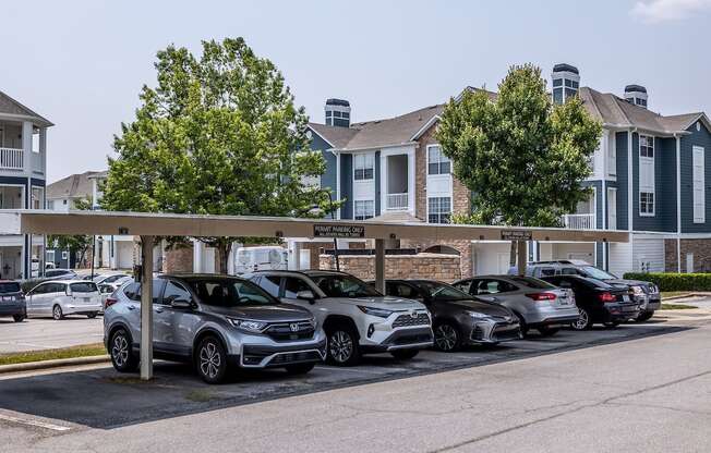 a row of cars parked in a parking lot in front of a building