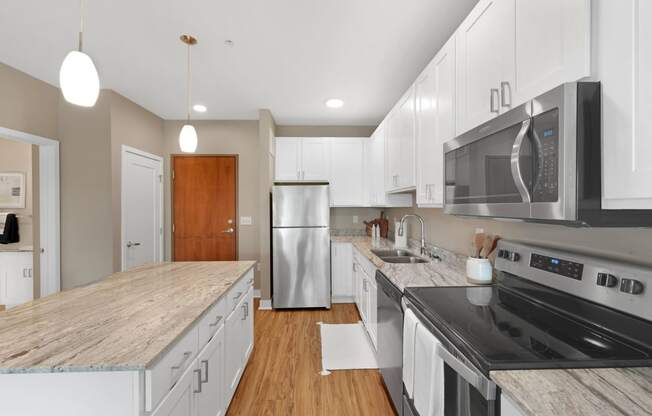 a kitchen with white cabinets and a wooden floor