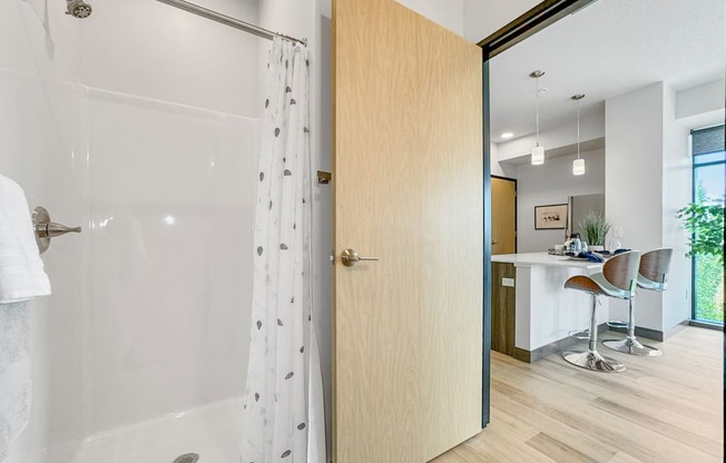 an open bathroom door leading to a shower with a curtain