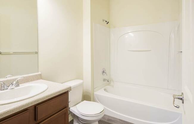 A white bathroom with a toilet, sink, and bathtub.