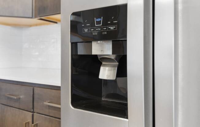 a stainless steel refrigerator with a coffee dispenser in a kitchen