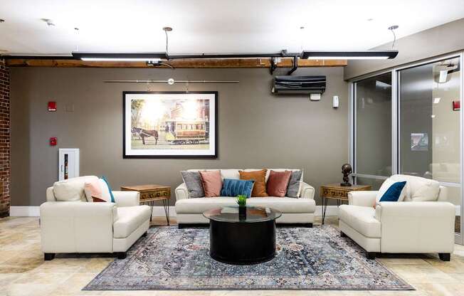 A living room with a large painting on the wall and a coffee table in the center.