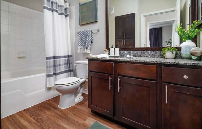 A bathroom with a toilet, sink, and a mirror.