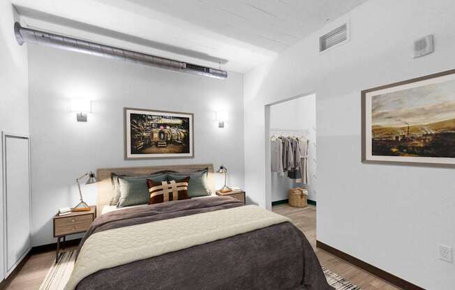 A bedroom with a large bed and two pictures on the wall.