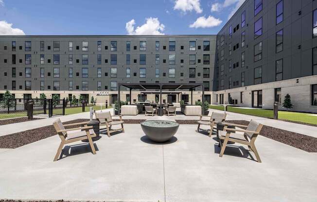 A courtyard with a fountain and benches in front of a building.
