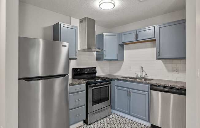 a kitchen with stainless steel appliances and blue cabinets