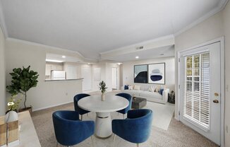 A white and blue living room with a round table and chairs.
