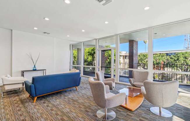 A living room with a blue sofa and a glass wall.