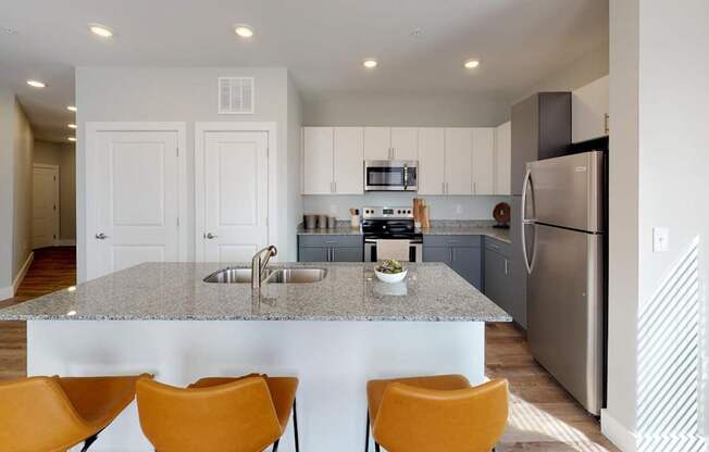 a kitchen with a granite counter top and a stainless steel refrigerator at Echo Park at Perry Crossing Apartments, Plainfield, Indiana