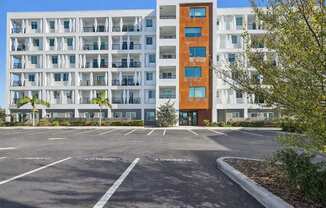A parking lot in front of a white and orange building.